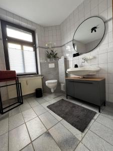 a bathroom with a sink and a toilet and a mirror at Ferienwohnung Uranus 1A in Annaberg-Buchholz +17 photos