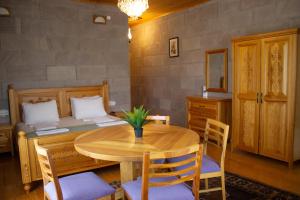 a dining room with a table and a bed at Lake Cildir Lodge in Çıldır +56 photos