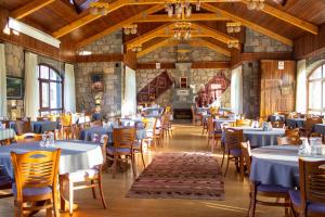 a dining room with blue tables and chairs at Lake Cildir Lodge in Çıldır