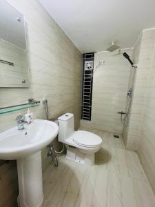 a bathroom with a toilet and a sink and a shower at Citylights Bashundhara Chelsea Majestic Collection in Dhaka