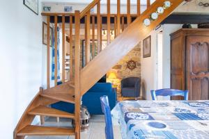 a wooden staircase in a room with a bed at Le Gaoulac'H I Vue mer & Grand jardin in Crozon