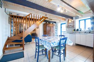 a kitchen and dining room with a table and a staircase at Le Gaoulac'H I Vue mer & Grand jardin in Crozon