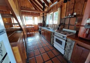 a kitchen with a stove top oven in a cabin at Ruma Andina by DOT Cabana in Villa La Angostura