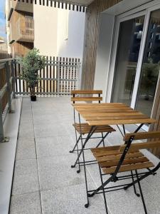 d'une table en bois et de bancs sur un balcon. dans l'établissement T3 Moderne - Proche tram - Parking privé, à Angers