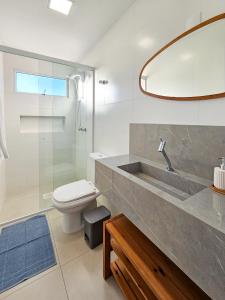 a bathroom with a sink and a toilet and a mirror at Novo e ao lado da Oktoberfest in Blumenau
