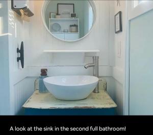 un lavandino nel secondo bagno completo con uno specchio di Just Add Water! a Secession Altre 10 foto