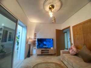 a living room with a couch and a flat screen tv at Un écrin rabati in Rabat