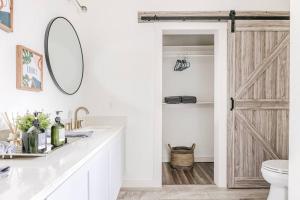 baño con aseo y puerta corredera de granero en 3BR Modern, Gated Home w FreePking, BBQ, Firepit, Mins to Downtown, en San Antonio 19 fotos más
