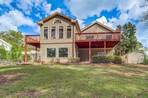 a house with a deck on top of a yard at Lakefront Home with Private Boat Dock on Lake Lanier in Murrayville