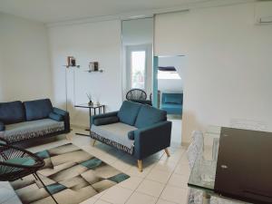 a living room with a couch and a chair at Appartement 2 terrasses face mer de 100m2 in Saint-Florent