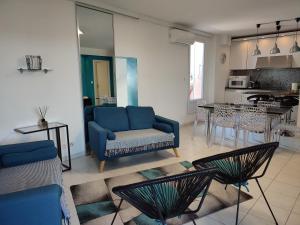 a living room with a blue couch and a kitchen at Appartement 2 terrasses face mer de 100m2 in Saint-Florent