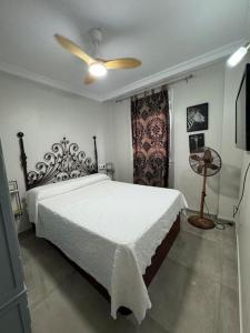 ラ・リネア・デ・ラ・コンセプションにあるCasa PRECIOSA ideal para familiasのベッドルーム(白いベッド1台、ファン付)