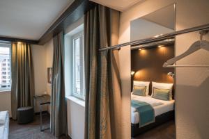 een hotelkamer met een bed en een raam bij Motel One Leipzig-Nikolaikirche in Leipzig