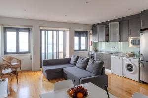 a living room with a couch and a kitchen at SpinBay Apartment in Espinho