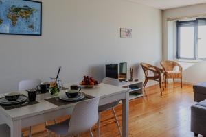 a kitchen and living room with a table and chairs at SpinBay Apartment in Espinho +10 photos