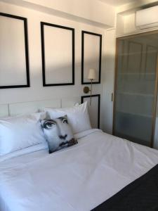 un letto bianco con la foto di una persona che lo osserva di Studio Lucas By Yoo Luxo a Porto Alegre