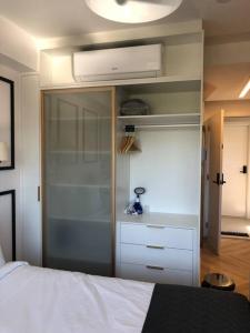 una camera da letto con un letto bianco e un armadio di Studio Lucas By Yoo Luxo a Porto Alegre