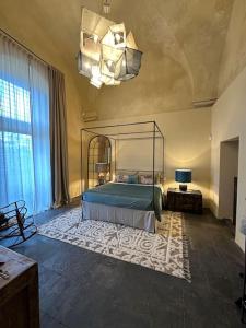 a bedroom with a bed and a chandelier at Dimora Enricuzzo Modica in Modica +39 photos