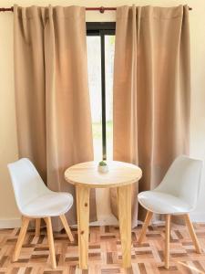 a table and two chairs in front of a window at Verenna Departamentos en Mar del Plata in Mar del Plata