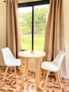 a table and two chairs in front of a window at Verenna Departamentos en Mar del Plata in Mar del Plata +15 photos