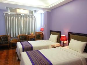 A bed or beds in a room at Grand Laurel Hotel
