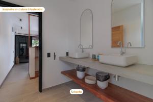 a white bathroom with two sinks and a mirror at Vila Juriti: Luxo Frente Mar no melhor do Fortim in Fortim +86 photos