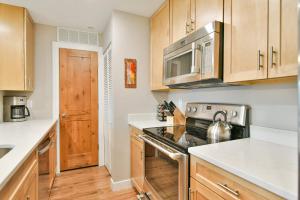 Una cocina con gabinetes de madera y un horno de estufa. en Lake Forest Lakeside Condo: Mountain, Lake Views, en Summit Medical Center Heliport