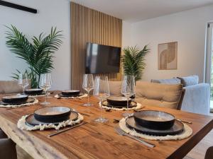 a wooden table with plates and wine glasses on it at SiOUX stilvolle Designapartments im Zentrum in Augsburg