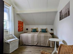 Un dormitorio con una cama, una mesa y una silla. en Spacious Bungalow near Water, en Breskens 26 fotos más