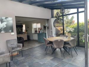 Una cocina y un comedor con mesa y sillas. en Spacious Bungalow near Water, en Breskens