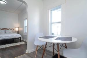 Camera bianca con tavolo, sedie e letto di Near Airport Parking Netflix Wi-fi a Thunder Bay