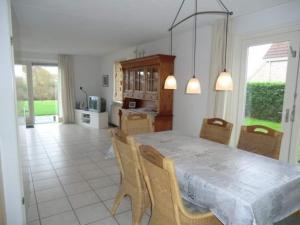 a kitchen and dining room with a table and chairs at Bungalow in Breskens near the Beach in Breskens