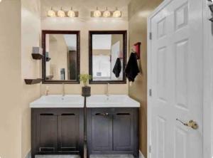 a bathroom with two sinks and two mirrors at A master suite with own kitchenette and bath in Walnut Creek