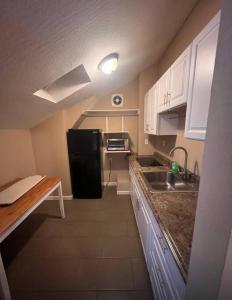 a small kitchen with a black refrigerator and a sink at A master suite with own kitchenette and bath in Walnut Creek