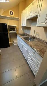 a kitchen with white cabinets and a sink at A master suite with own kitchenette and bath in Walnut Creek +4 photos