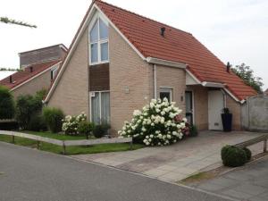 ein braunes Backsteinhaus mit rotem Dach in der Unterkunft Bungalow in Breskens near the Lighthouse in Breskens