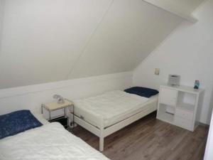 two beds in a room with a attic at Bungalow in Breskens near the Beach in Breskens +30 photos