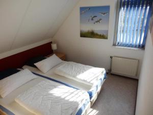 zwei Betten in einem kleinen Schlafzimmer mit Fenster in der Unterkunft Bungalow in Breskens near the Lighthouse in Breskens + 28 Fotos