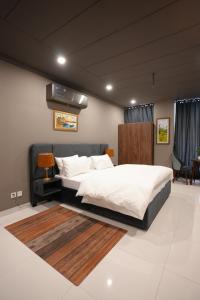 a bedroom with a large bed with white sheets at Hotel Crossroads in Islamabad