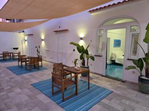 a living room with tables and chairs and a room at Chiaia Di Rose Rooms & Apartment in Ischia