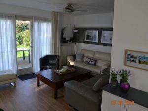 una sala de estar con un sofá y una mesa en Bungalow in Breskens near Beach & Lighthouse, en Breskens