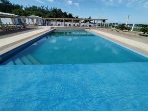 una grande piscina blu con acqua blu di Hotel Villas Xali a Barra de Tuxpan
