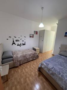 a bedroom with two beds and a couch in it at Elbasan center apartment in Elbasan +9 photos