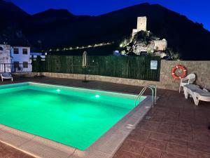a swimming pool at night with a castle in the background at Casa Angel in Cazorla