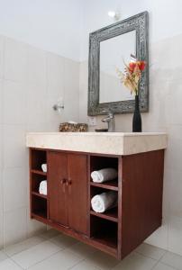 W łazience znajduje się umywalka i lustro. w obiekcie Sunhouse Guesthouse w mieście Sanur