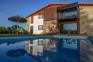 una casa con piscina accanto a un edificio di Casa D'Augusta - Agroturismo a Miranda do Douro