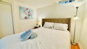 a bedroom with a bed with a cat sitting on it at Cozy Walkout Basement with Tranquility in Toronto