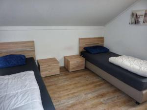 Dos camas en una habitación con suelo de madera. en Coastal Bungalow w Garden, en Breskens 28 fotos más