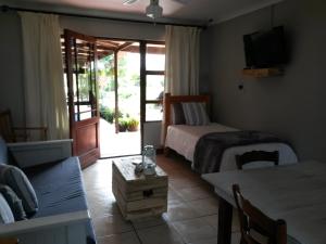 een slaapkamer met een bed, een tafel en een bank bij African Sun Guest House in Molen Drift