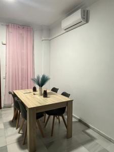 a dining room with a wooden table and chairs at Casa dalia in Moguer